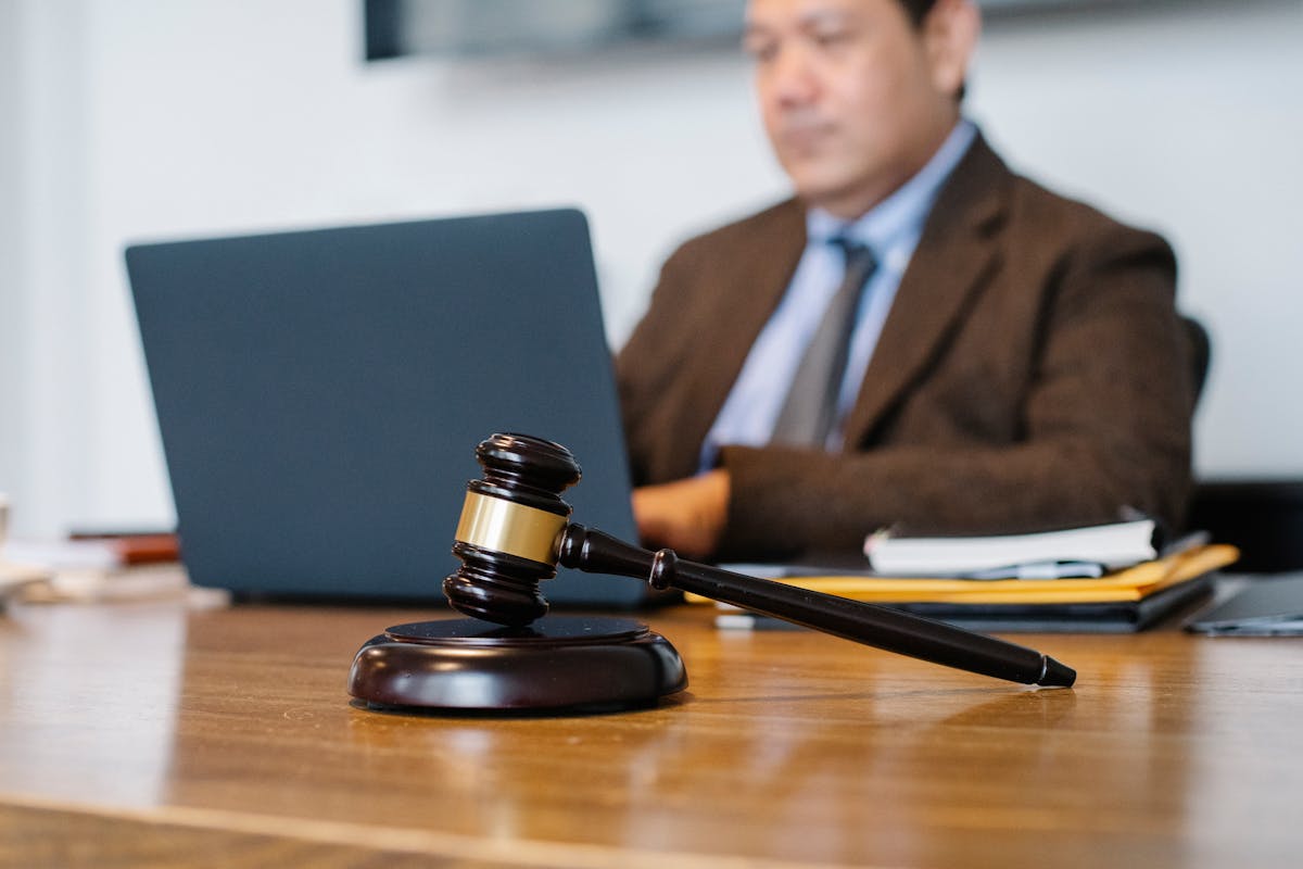 Crop Asian judge working on laptop in office